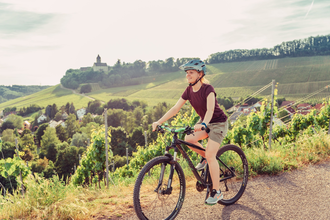 Radfahrerin am Schöllkopf in Brackenheim am Württemberger Weinradweg | © Touristikgemeinschaft HeilbronnerLand e.V.