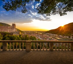 Panorama der Heidelberger Altstadt mit dem Heidelberger Schloss auf einem Hügel, umgeben von grüner Landschaft bei Sonnenuntergang | © Heidelberg Marketing GmbH, Foto Tobias Schwerdt