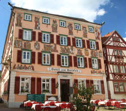 Historische Fachwerkhäuser in Eberbach neben einer schmalen Gasse, davor das Hotel Karpfen mit Tischen und roten Stühlen im Freien | © Landratsamt Rhein-Neckar-Kreis