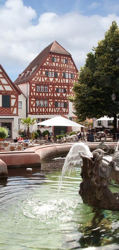 Brunnen mit Drachenfigur im Wasser vor Fachwerkhäusern am Ladenburger Marktplatz bei sonnigem Himmel | © Landratsamt Rhein-Neckar-Kreis; Foto Dorothea Burkhardt