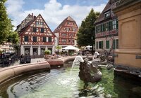 Brunnen mit Drachenfigur im Wasser vor Fachwerkhäusern am Ladenburger Marktplatz bei sonnigem Himmel | © Landratsamt Rhein-Neckar-Kreis; Foto Dorothea Burkhardt